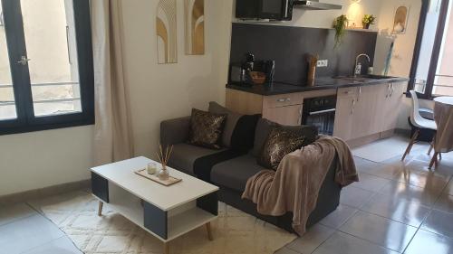 un salon avec un canapé et une table dans l'établissement COSY CLIM CENTRE VILLE, à Montélimar