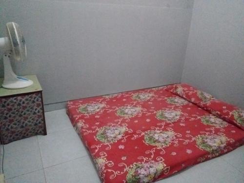 una cama roja en una esquina de una habitación en HOMESTAY SYARIAH GRIYO VIEW SAWAH, en Godean