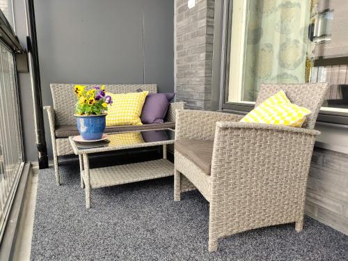 un porche con 2 sillas y un jarrón de flores en Fully Equipped New Apartment With Free Parking, en Tampere