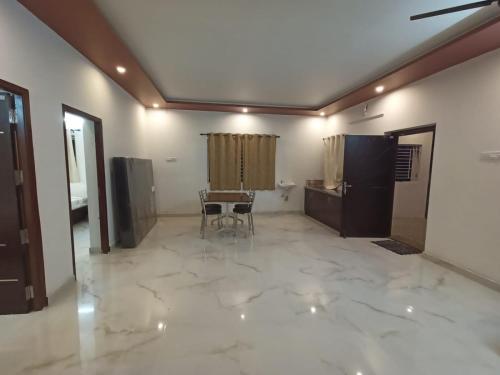 a living room with a table and a chair at Sushmika Villas in Yercaud