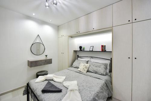 una camera bianca con letto e specchio di Home sweet home. a Heraklion