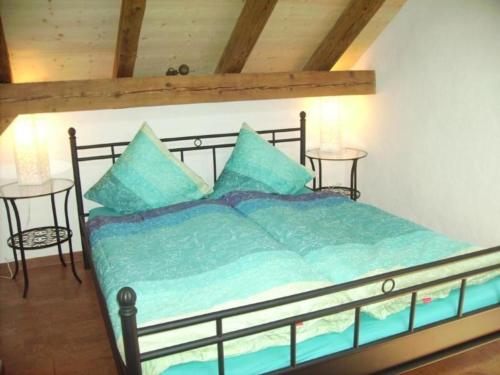 um quarto com uma cama com lençóis azuis e duas mesas em mountain-panorama DG 4-Bettwohnung em Meiringen