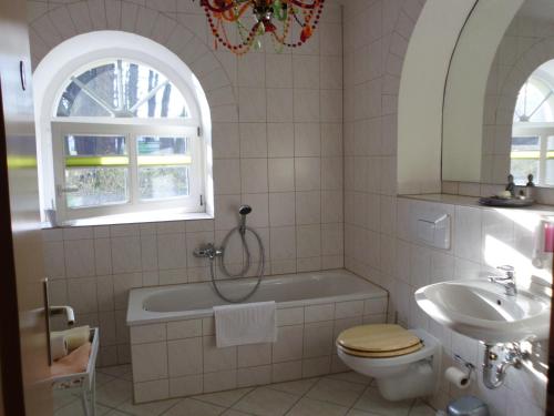 ein Badezimmer mit einer Badewanne, einem WC und einem Waschbecken in der Unterkunft Grüne Villa in Kromlau