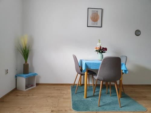 uma sala de jantar com uma mesa azul e cadeiras em Apartmani Sunflower em Sremski Karlovci