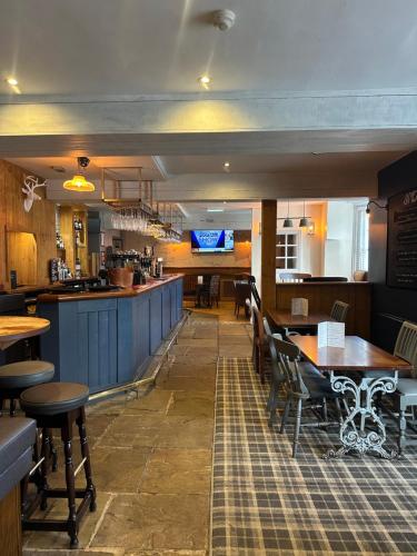 un ristorante con tavoli e sedie e un bar di Red Lion Coaching Inn a Redbourne