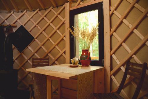 een kleine tafel in een kamer met een raam bij Lapiland - off-grid yurts & tipis - the place to reconnect with nature 