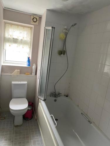 een badkamer met een bad, een toilet en een douche bij Cavendish house in Strawberry Hill