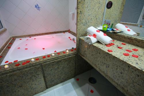 a bathroom with a tub filled with red pills at Lina Motel Tatuapé in Sao Paulo