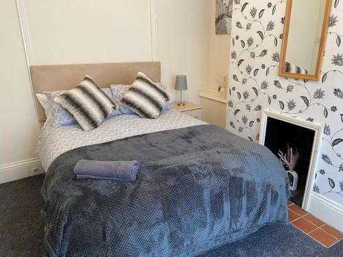 a bedroom with a bed with pillows and a fireplace at Salisbury House in Kettering