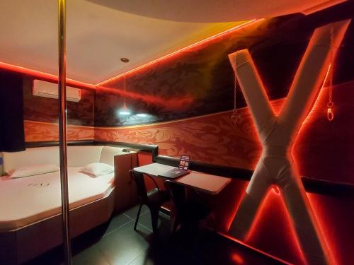 a room with a bed and a table with a cross on the wall at Lina Motel Tatuapé in São Paulo
