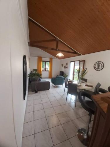 a living room with a couch and a table at Yellow little house in Le Bois de Nèfles