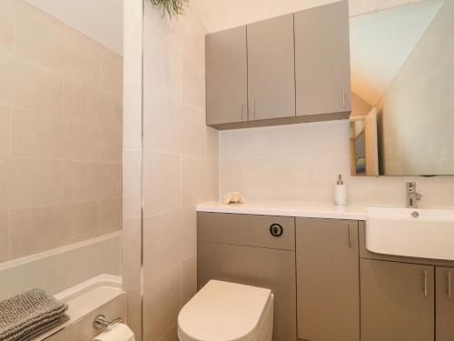 a small bathroom with a toilet and a sink at Lilac Cottage in Lymington