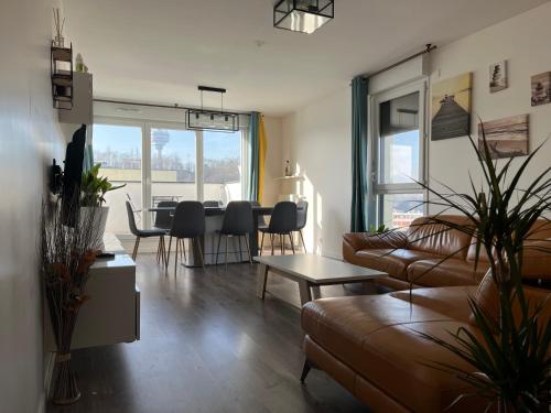 un salon avec un canapé et une table dans l'établissement Appartement de Romainville, à Romainville