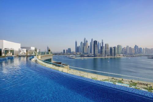 ein großer Wasserkörper mit einer Stadt im Hintergrund in der Unterkunft NH Collection Dubai The Palm in Dubai