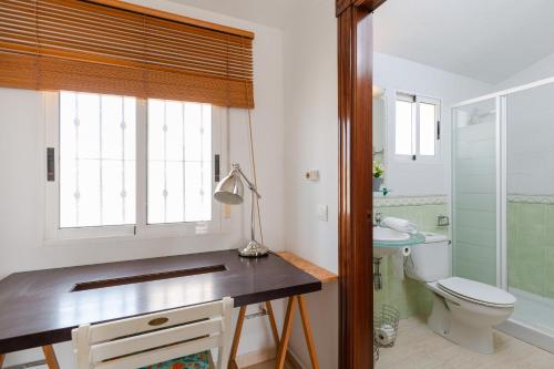 uma casa de banho com um lavatório, um WC e uma janela. em Bliss Moments by Fidalsa em Torre de la Horadada