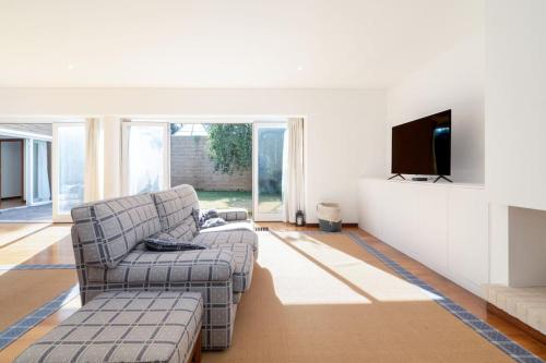 a living room with a couch and a flat screen tv at Quinta da Barca Guest House in Esposende
