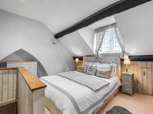 a bedroom with a large bed and a window at Wisteria Cottage in Nantwich