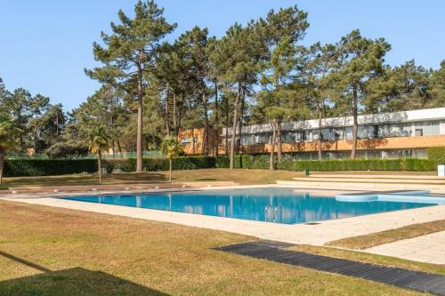 a swimming pool in a park with a building in the background at Quinta da Barca Guest House in Esposende