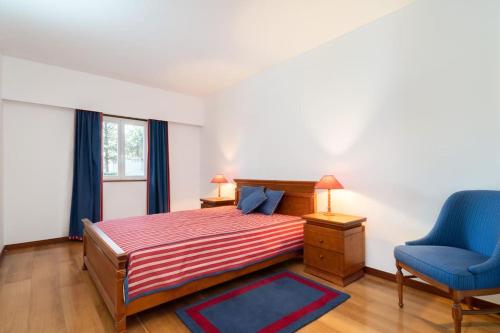 エシュポゼンデにあるQuinta da Barca Guest Houseのベッドルーム1室(ベッド1台、青い椅子付)