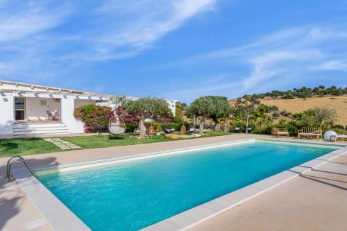 a swimming pool in front of a house at Le Valli di Vendicari in Noto Marina