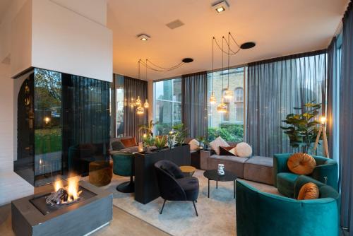 a living room with couches and a fireplace at Ariane Hotel in Ieper