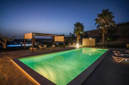 a swimming pool in a backyard at night at Le Valli di Vendicari in Noto Marina