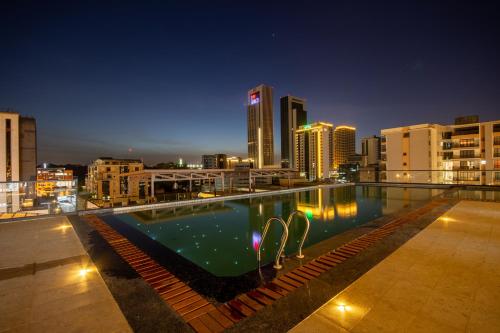 a swimming pool on the roof of a building at night at Broadwalk Residency in Nairobi