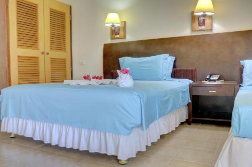 a bedroom with a blue bed with flowers on it at Honiara Hotel in Honiara