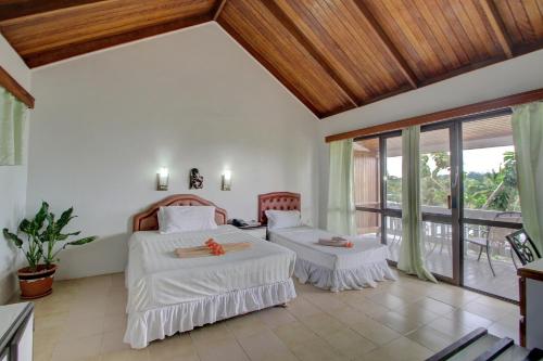 a bedroom with two beds and a balcony at Honiara Hotel in Honiara