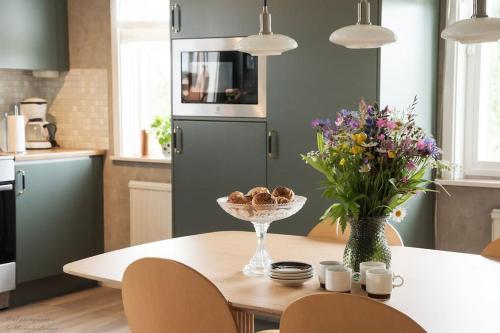 una cocina con una mesa con un jarrón de flores en Villa på lantlig idyll i Källunga, Herrljunga, en Herrljunga