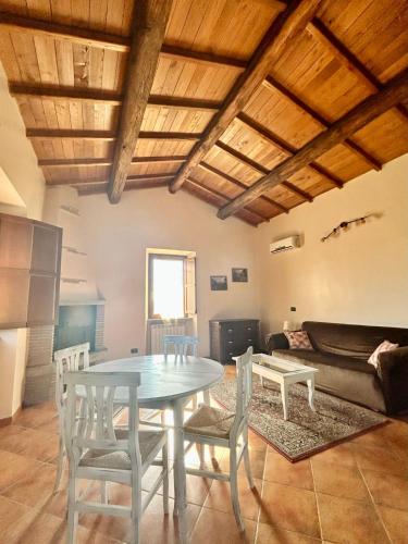 a living room with a table and chairs and a couch at Podere La Branda in Vetralla