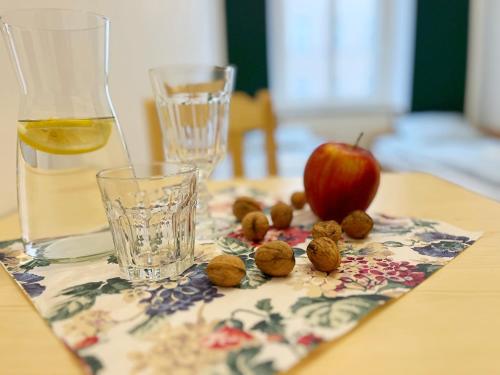 an apple and olives on a table next to a glass at Noclegi Pan Tadeusz in Wałbrzych
