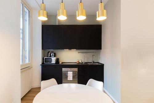 a kitchen with a white table and white chairs at Milan Retreats in Milan