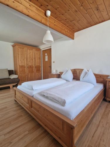a large bed in a bedroom with a wooden ceiling at Haus Beim Seppl in Naturno