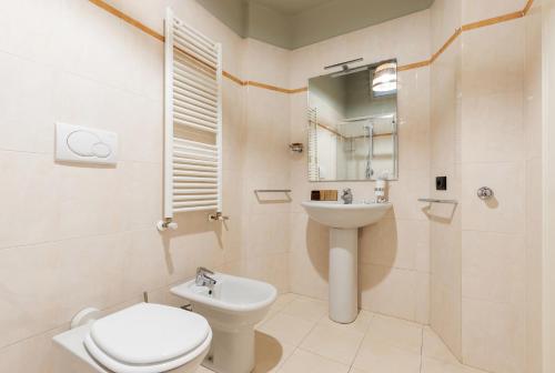 a white bathroom with a toilet and a sink at Milan Retreats in Milan