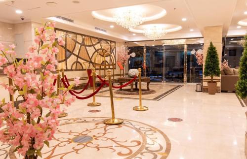 een lobby met roze bloemen en een rood lint bij بيوتات الحور in Taif