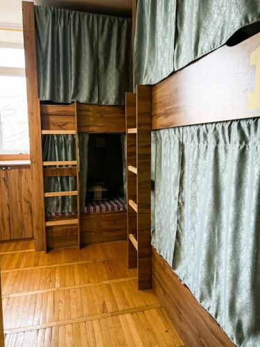 a bunk bed in a room with wooden floors at Golden Square in Almaty