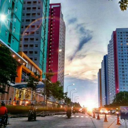 una calle de la ciudad con muchos edificios altos y coches en Green Pramuka City, en Yakarta