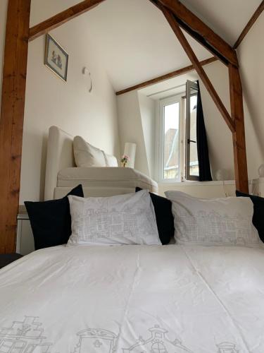 a bedroom with a bed with white sheets and pillows at Olives in Brussels