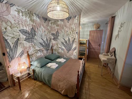 - une chambre avec un lit et un papier peint floral dans l'établissement Maison de campagne chez Mamie 4 étoiles, à Sainte-Eulalie-dʼAns