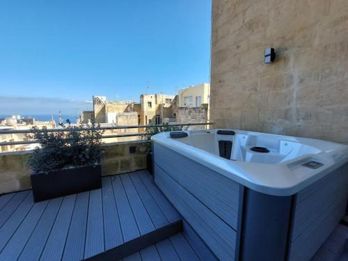 a bath tub sitting on top of a balcony at The Capital Boutique Hotel in Valletta