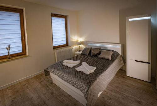 a bedroom with a bed with two towels on it at APARTHOTEL Wałcz in Wałcz