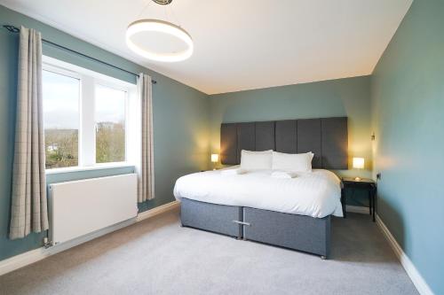 a bedroom with a large bed and a window at Cheshire Mews in Castleton