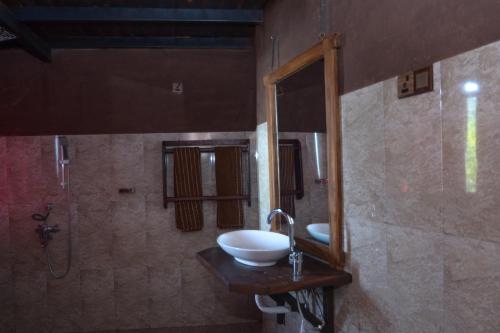 a bathroom with a sink and a mirror at Ella Camelot in Ella