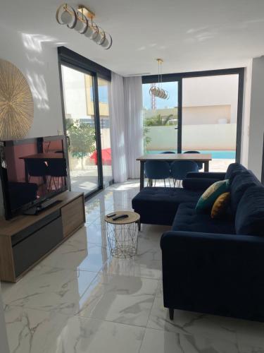 sala de estar con sofá azul y TV en Luxury Villa with private pool, en Los Montesinos