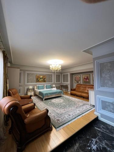 a living room with a bed and a couch at TURAN SEMEY GRAND HOTEL in Semey