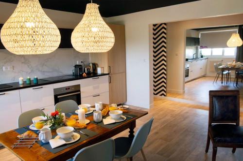 - une cuisine et une salle à manger avec une table et des chaises dans l'établissement Gîte des Puys - Pinatelle - Durtol, à Durtol