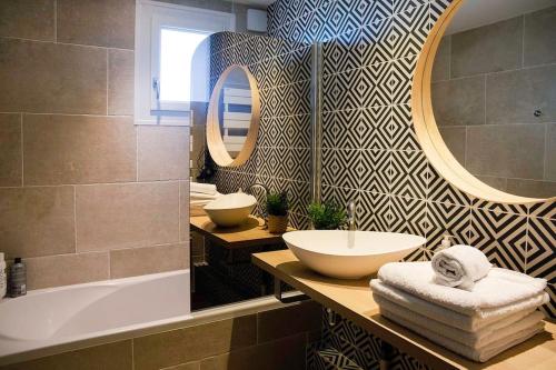 a bathroom with a sink and a tub and a mirror at Gîte des Puys - Pinatelle - Durtol in Durtol