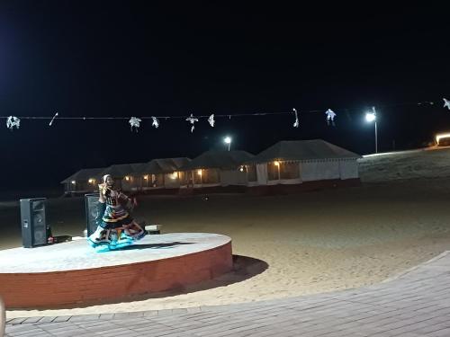 a statue of a person sitting on a wire at night at Bikaner Desert Camp and Resort in Bikaner