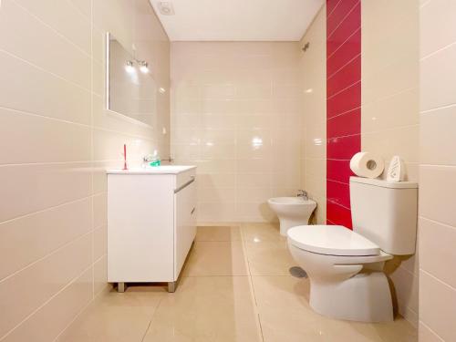 ein weißes Badezimmer mit Toilette und Waschbecken in der Unterkunft Appartement - Plage de Furadouro - Rico's Homes in Ovar